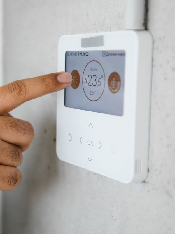A person messing with a thermostat.